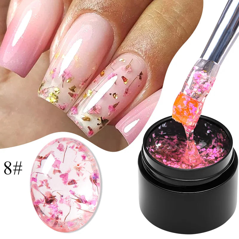 Pink gel nail polish with gold and pink dried flowers on clear nail base and gel bottle