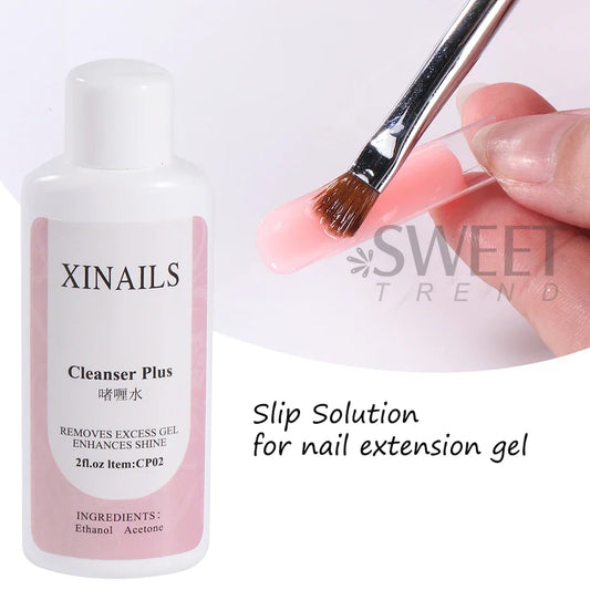 XINAILS cleanser plus bottle with nail brush applying on a manicured nail