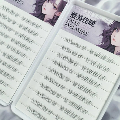 False eyelash lash sets on a storage tray with multiple wispy cluster rows