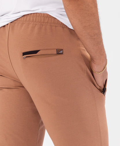 Rust-brown tapered athletic sweatpants detail with drawstring waistband and side pocket