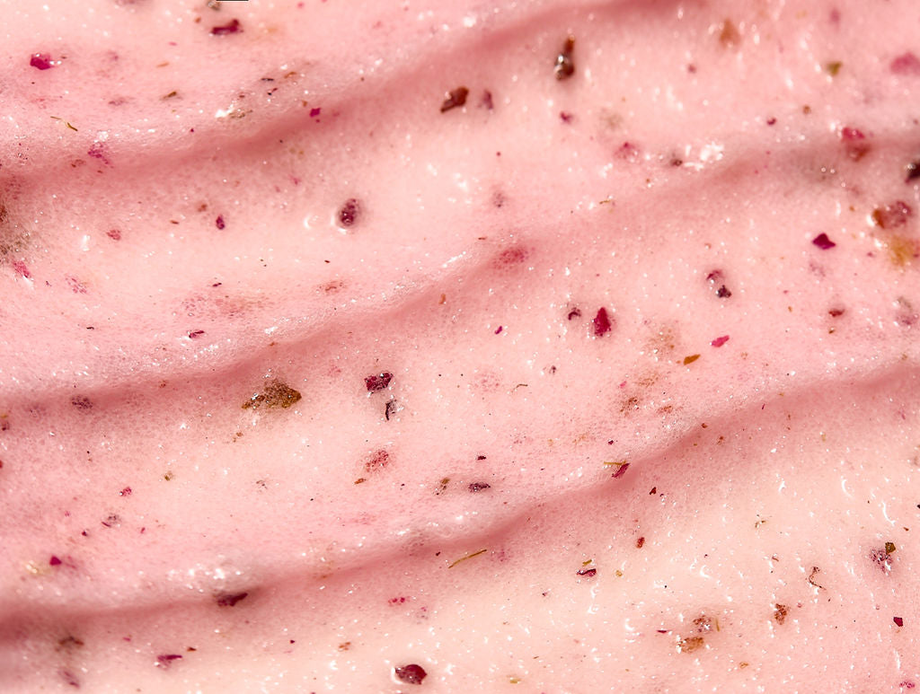 Pink body scrub texture with dark exfoliating particles