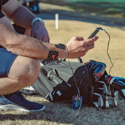 Muscle stimulator electrode pads attached on arm with controller and cables