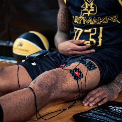 Muscle stimulator electrode pads on thigh with connected cables