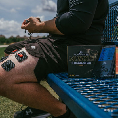 Muscle stimulator pads on leg with control unit and product box beside it