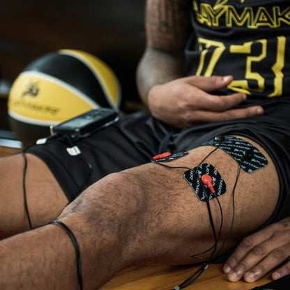 Muscle stimulator electrode pads on thigh with attached cables
