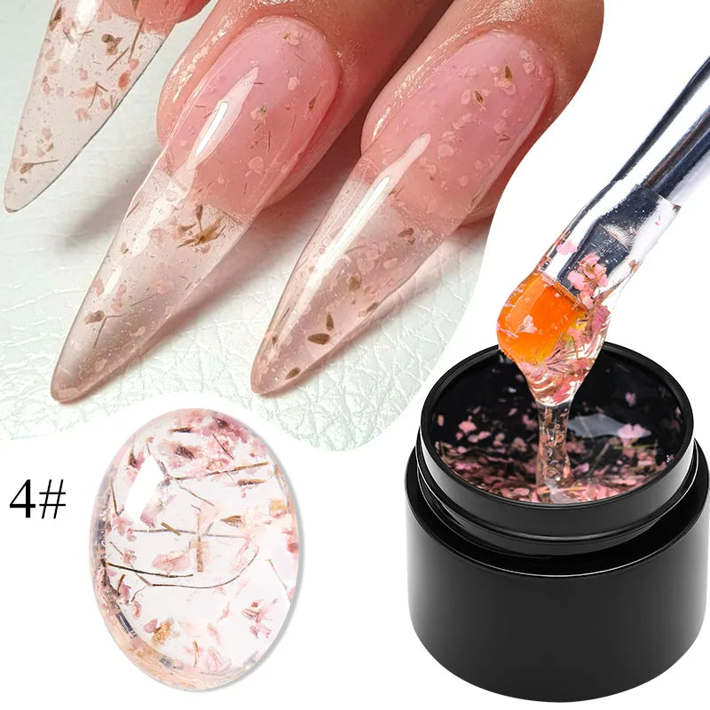 Flower fairy gel nail polish on nude pink nails with brown dried flower flakes; jar shown