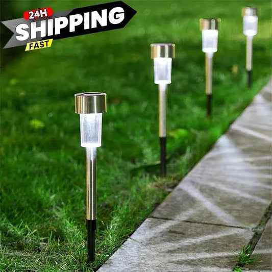 Solar garden lantern light with metal stake and clear glass sleeve, standing on grass