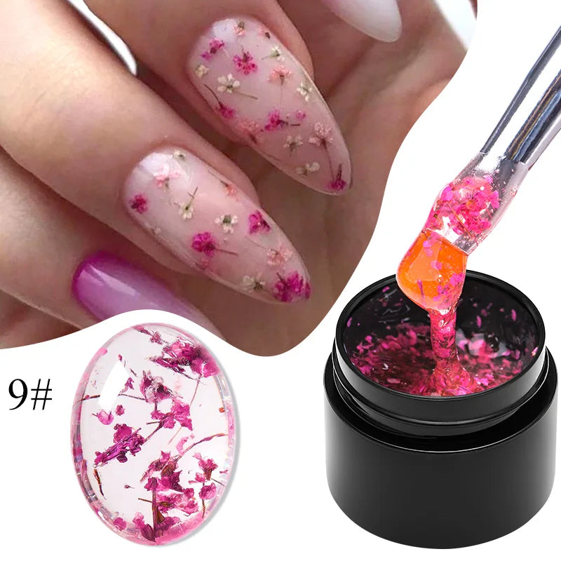 Purple gel nail polish with pink and gold dried flower nail designs and gel bottle