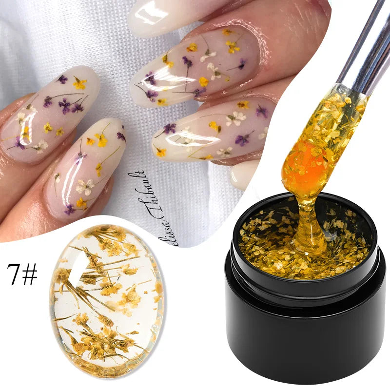 Flower fairy gel nail polish on sheer nails with golden dried flower flakes; jar shown