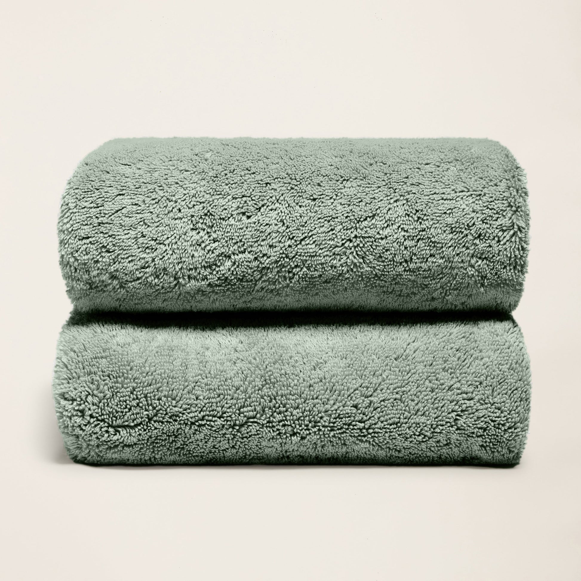 Plush cotton towels, deep sage green, two folded towels with thick pile