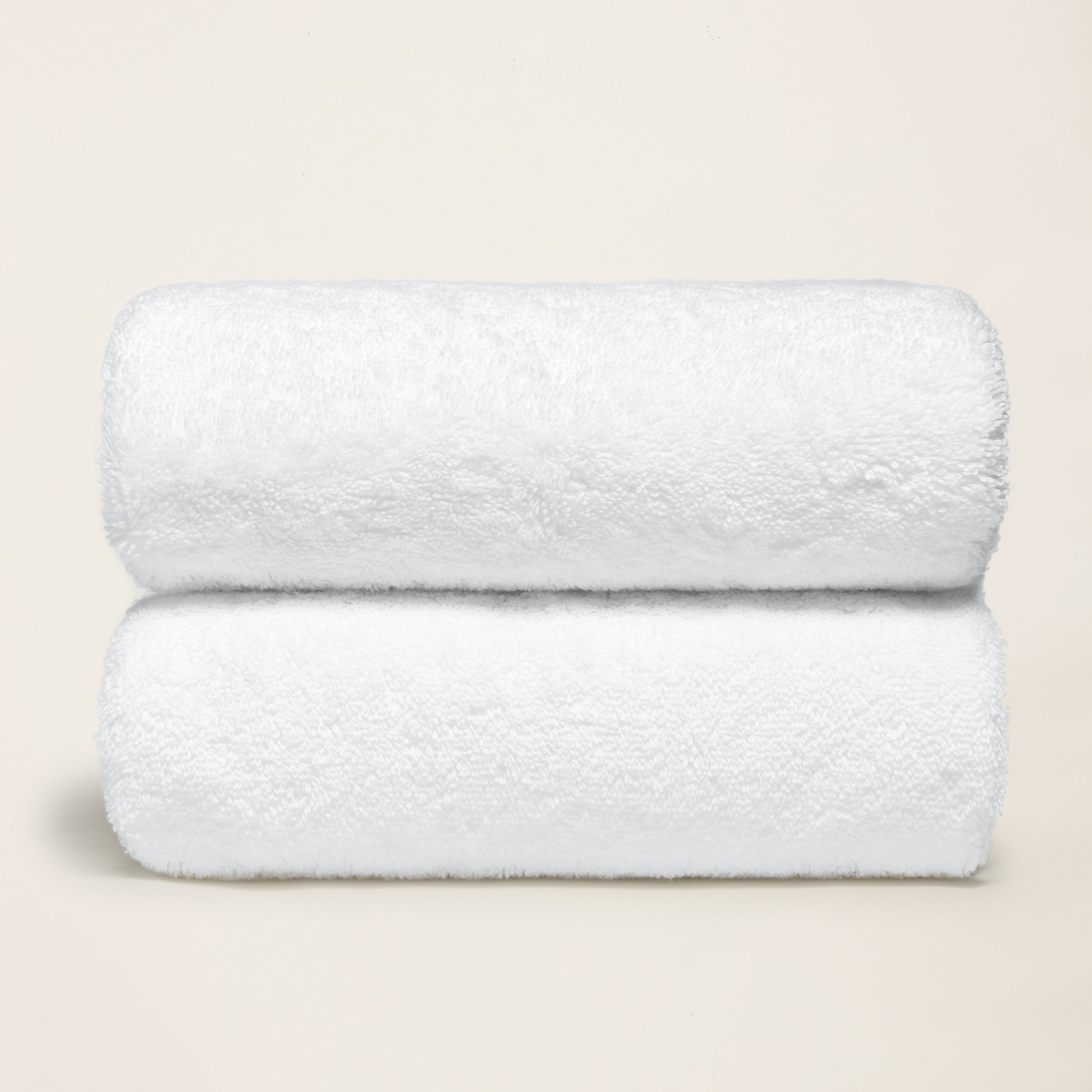 White cotton towel set, plush folded towels with thick terry loop texture