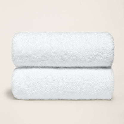 White cotton towel set, plush folded towels with thick terry loop texture