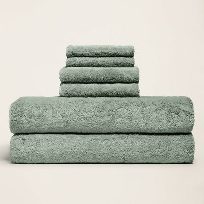 Dark green plush towels stacked and folded, thick terry texture