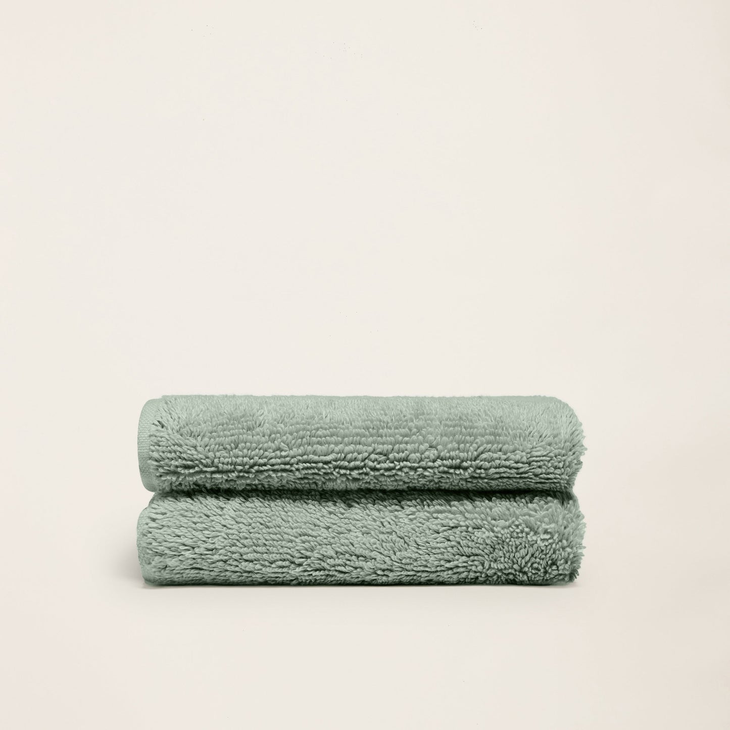 Plush cotton towels, mint green, two folded towels on a plain background