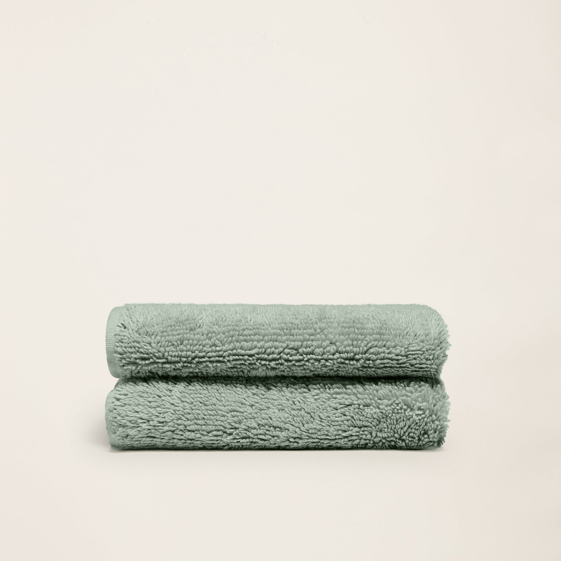 Plush cotton towels, mint green, two folded towels on a plain background