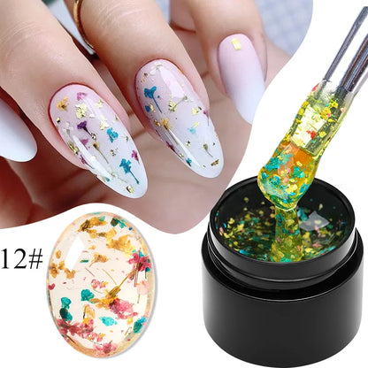 White gel nail polish with multicolor dried flowers on nails and gel bottle labeled 12