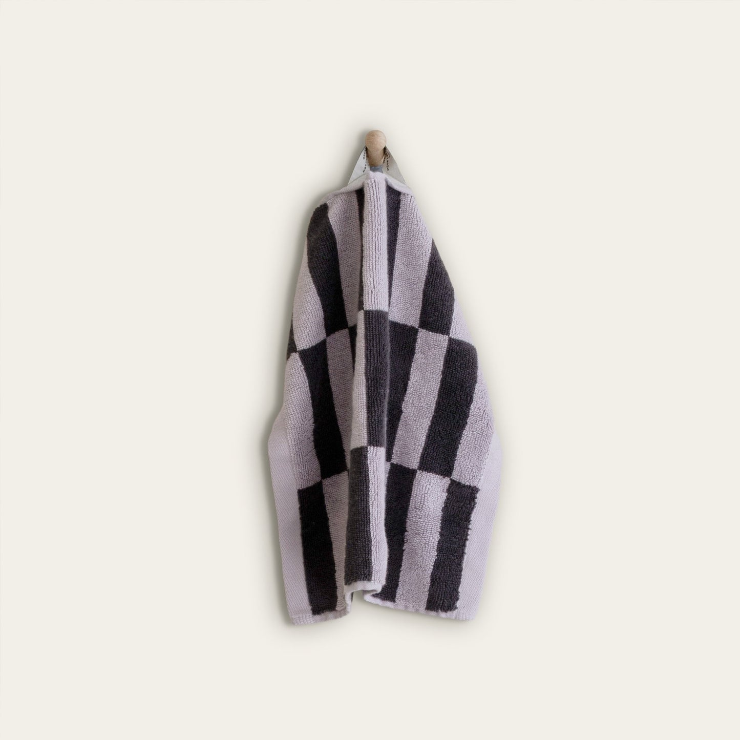 Lilac and charcoal checkered cotton towel, folded and hanging
