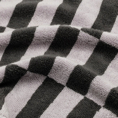 Close-up cotton towel fabric with lilac, light gray, and dark charcoal checker stripes