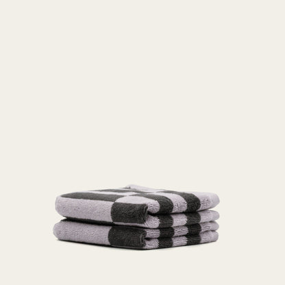 Rolled cotton towels in lilac and charcoal with black-and-lilac checker stripe pattern