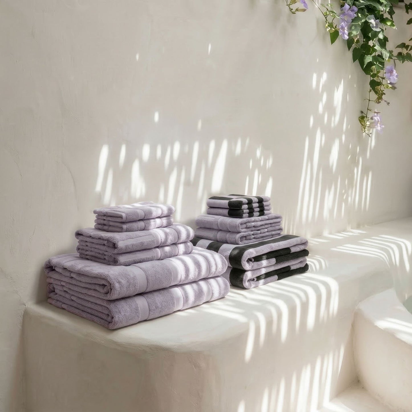 Folded lilac and charcoal checkered cotton towels arranged on a white ledge