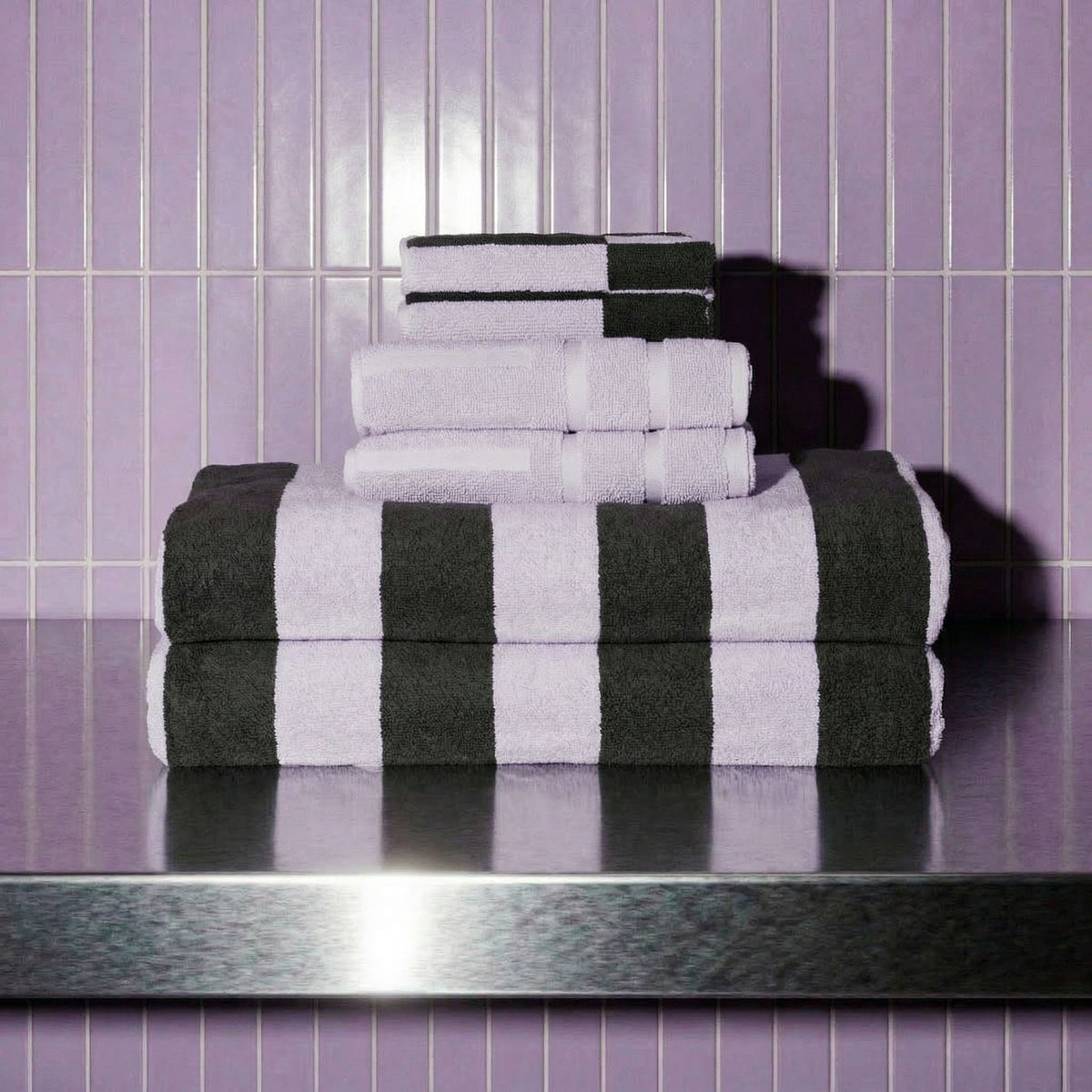 White and dark towels folded stack with bold black stripe accents, terry texture