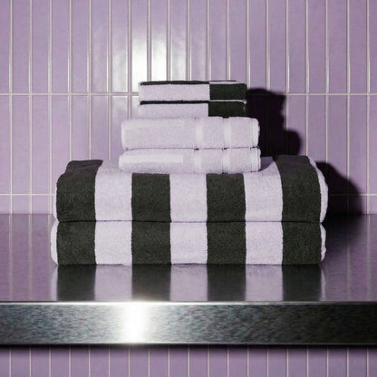 White and dark towels folded stack with bold black stripe accents, terry texture