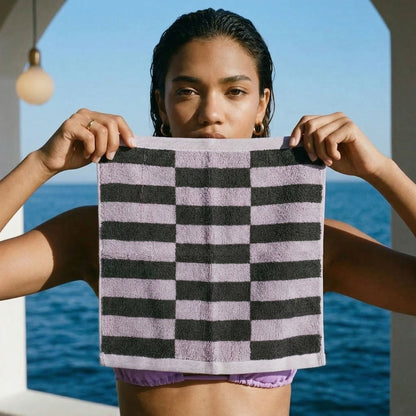 Lilac and charcoal checkered cotton towel held up for a close view