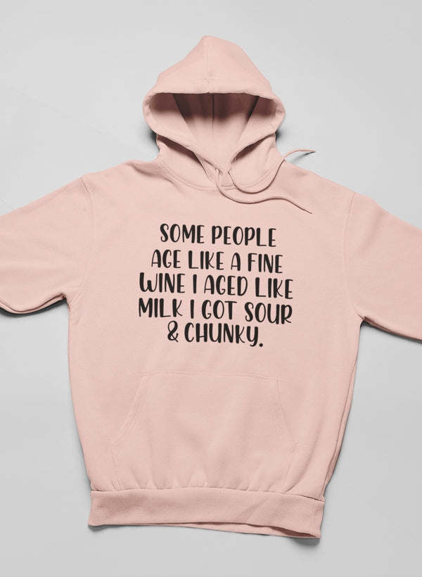 Peach pullover hoodie with hood, long sleeves, and center front text graphic