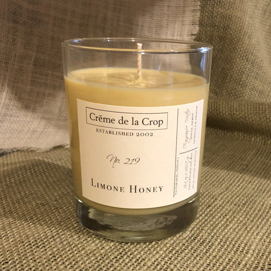 Soy candle in clear glass with exposed wick, yellow-gold wax