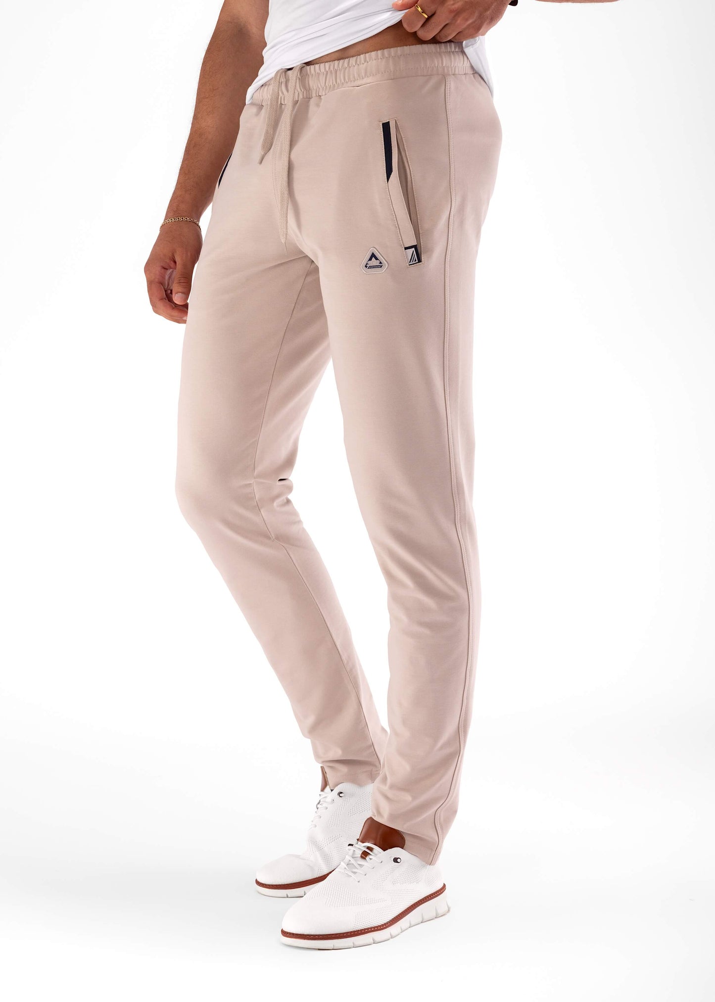 Athletic sweatpants with tapered legs, elastic waistband, and drawstring; light khaki color.