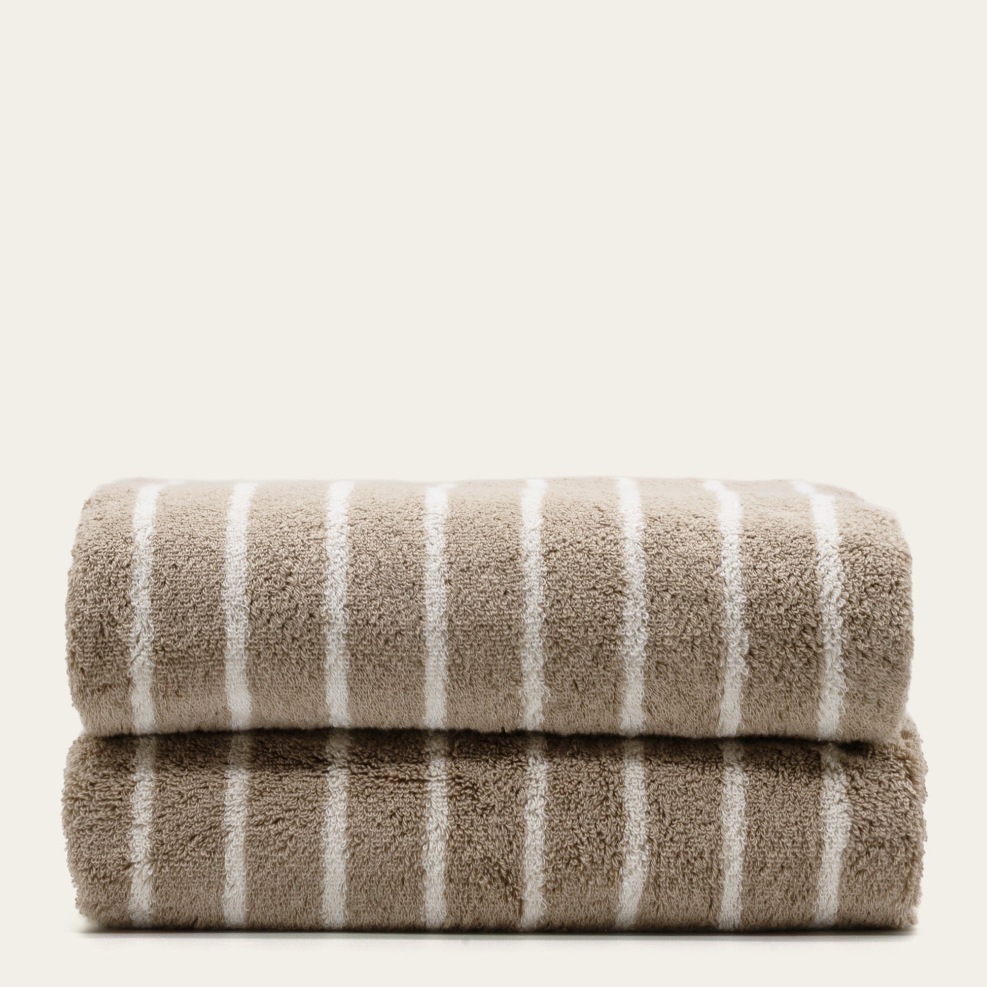 Striped cotton bath towels, stacked with taupe face and white vertical stripes