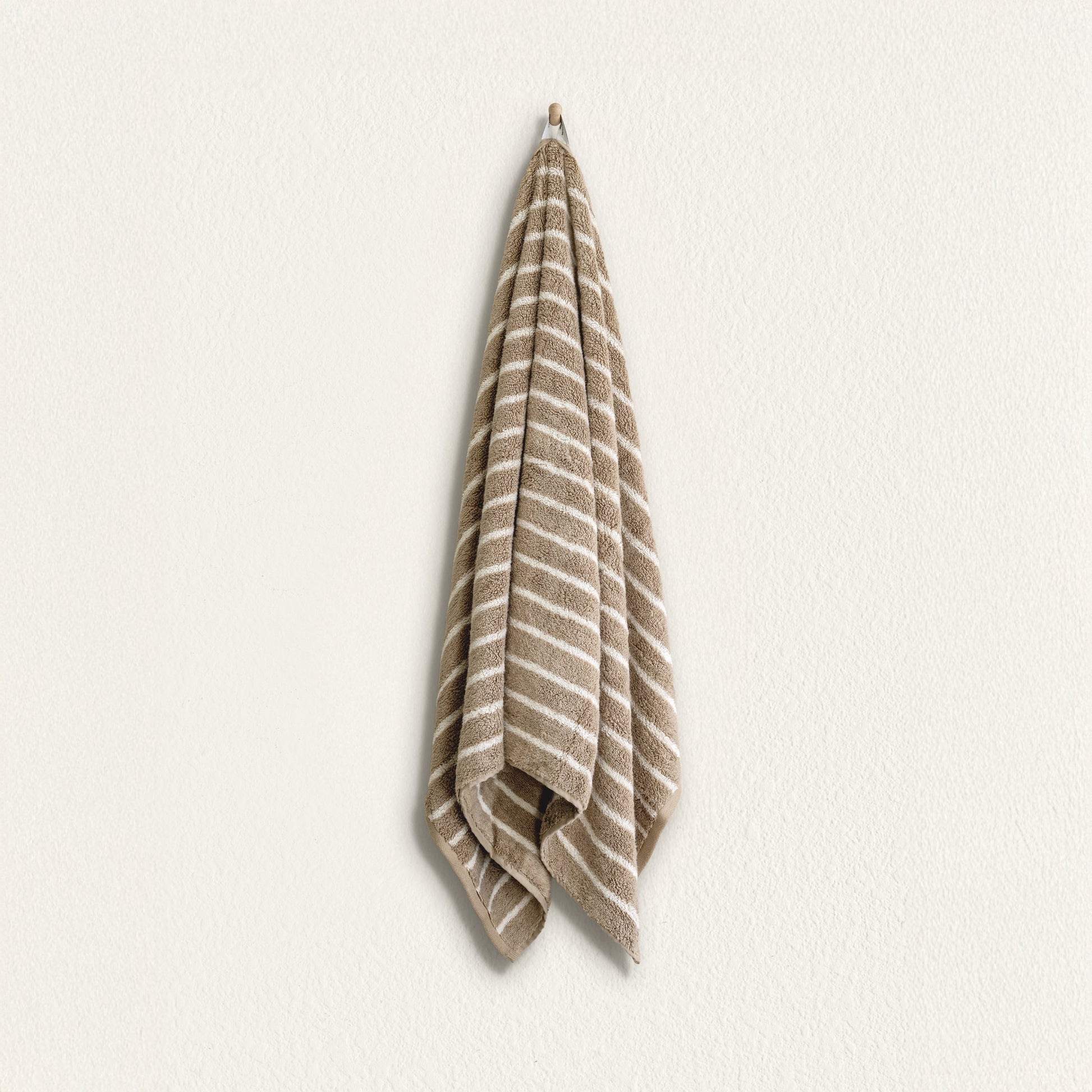 Striped cotton hand towel hanging, taupe and white stripes with looped terry edge