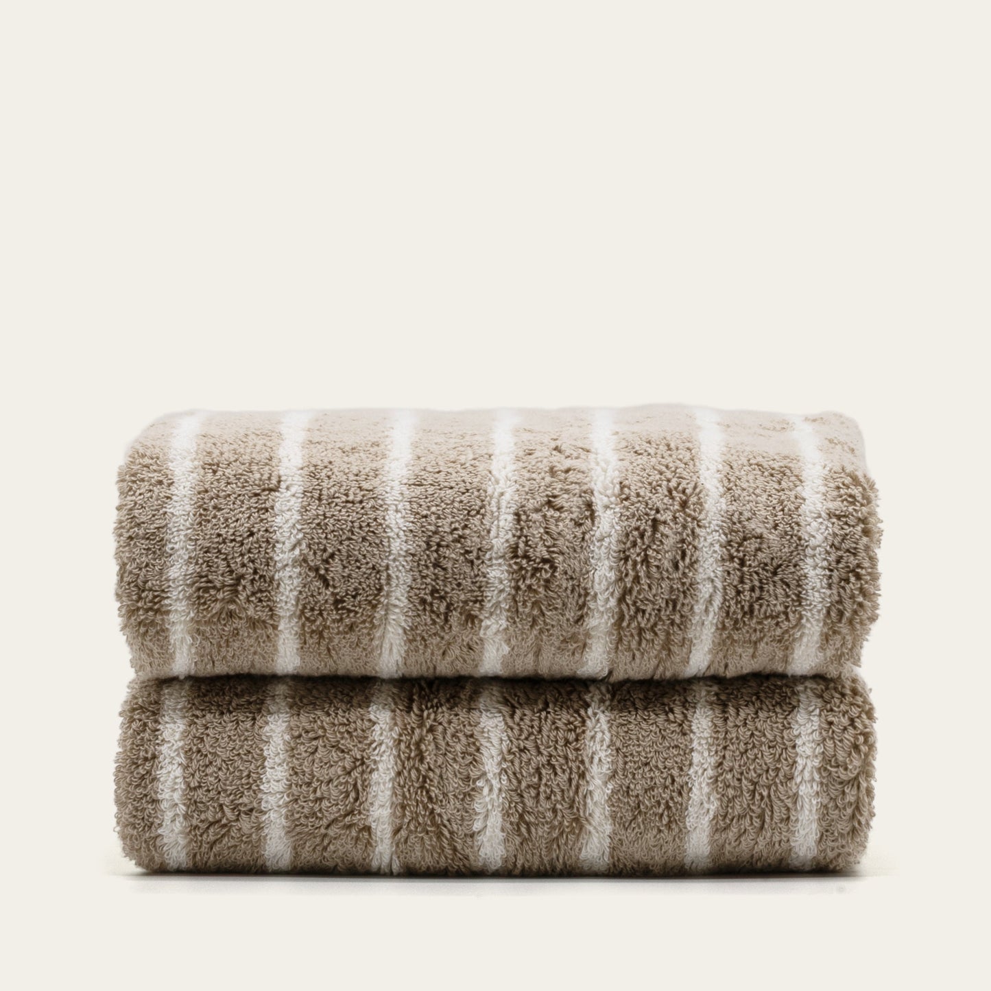Striped cotton bath towels, folded stack with taupe base and white vertical stripes