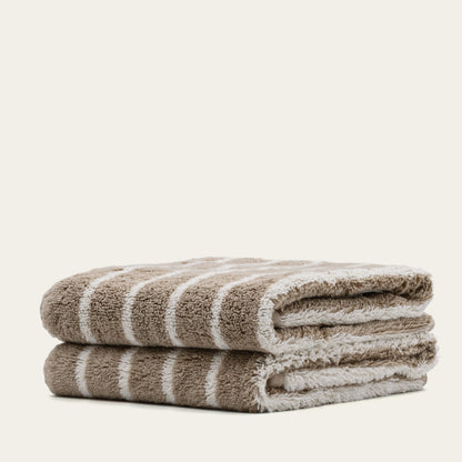 Stacked folded terry cotton towels with beige and white stripes