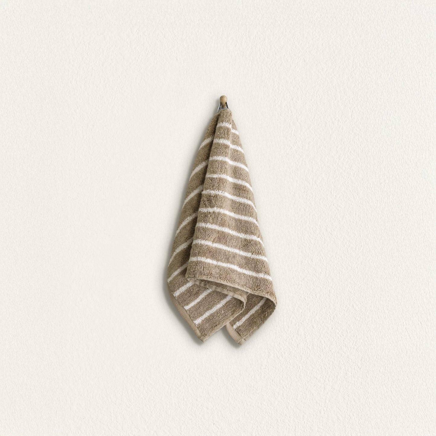 Striped cotton hand towel hanging, taupe with wide white stripes and terry border