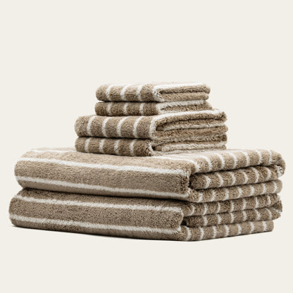 Striped towels set, beige and white plush cotton loops, folded and stacked