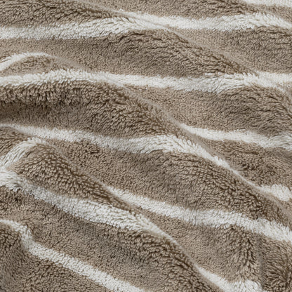 Striped terry cotton towel close-up, with beige and white bands