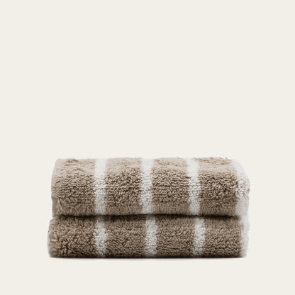 Folded terry cotton towel with beige and white stripes