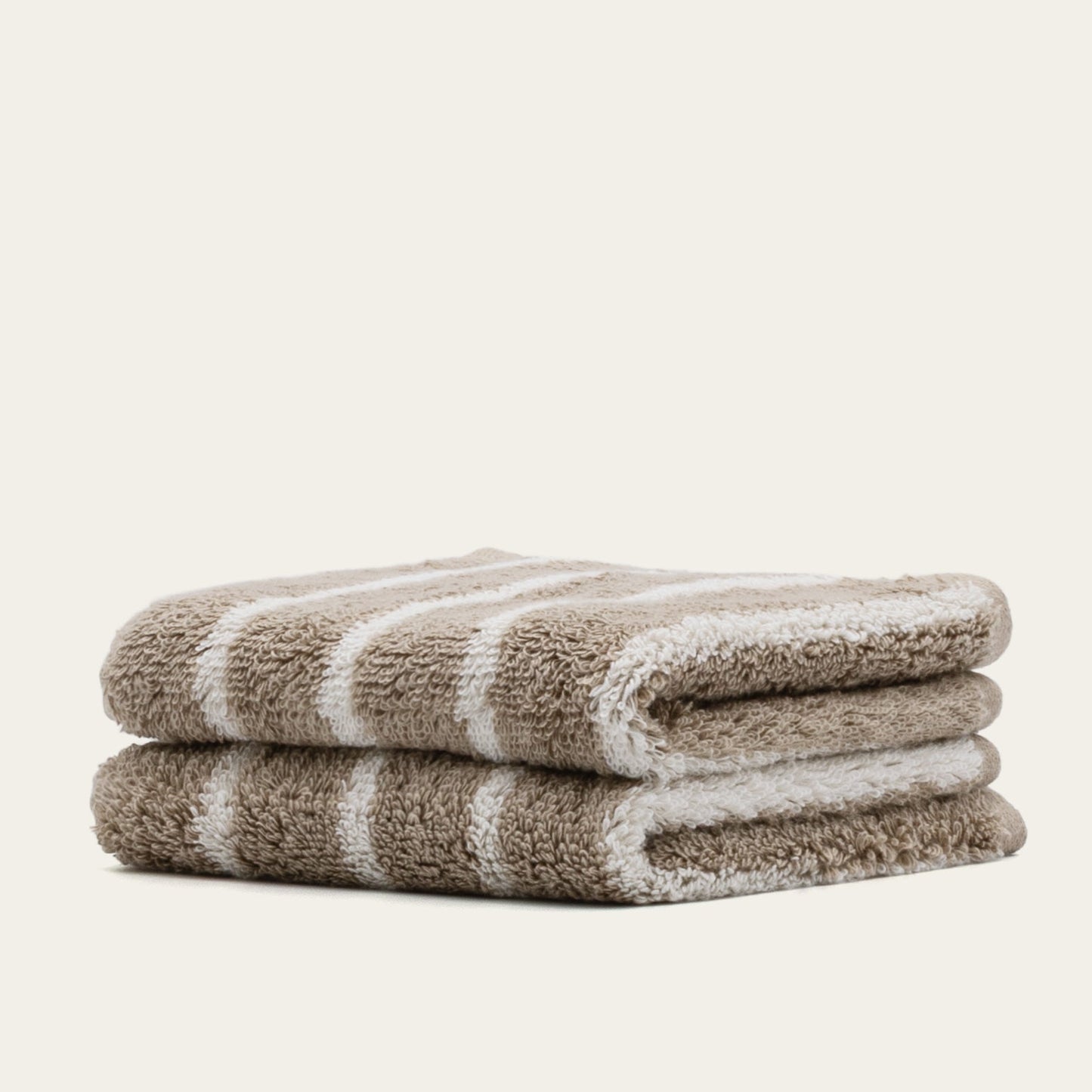 Folded terry cotton towel with light beige and white stripes