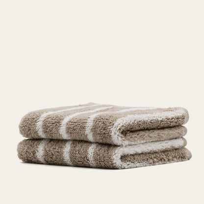 Folded terry cotton towel with light beige and white stripes