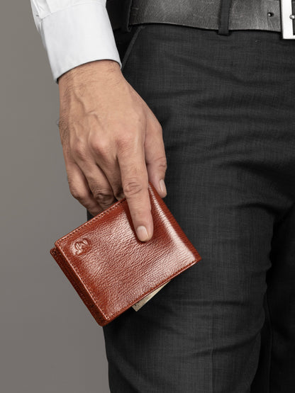 Men's tan-brown leather wallet held in hand, front cover facing up