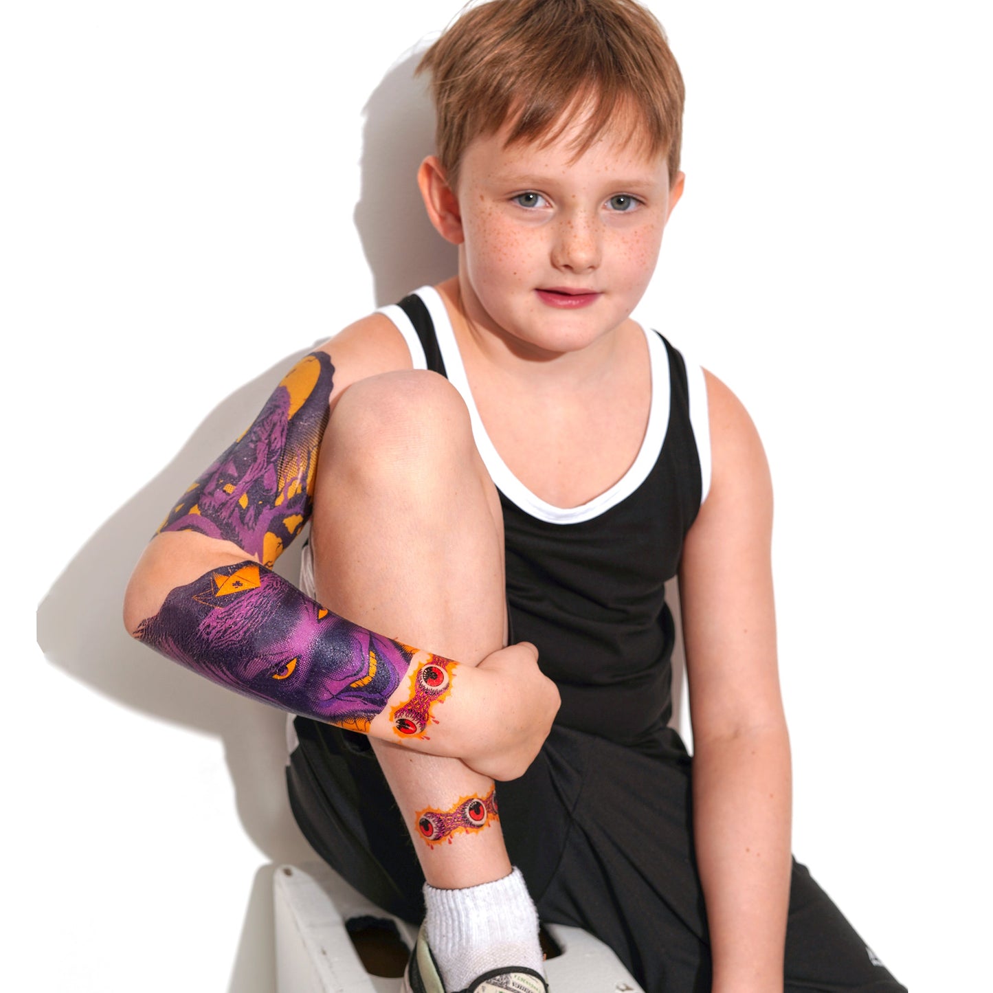 Kids temporary tattoo sleeve on boy’s forearm, purple-and-yellow wolf design