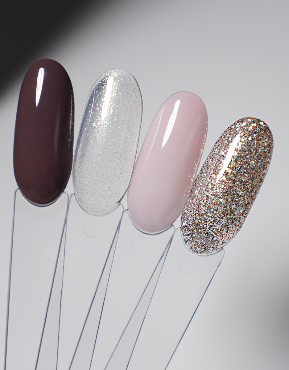 Nail polish swatch set with four glossy tips in dark burgundy, silver glitter, blush pink, and gold glitter.