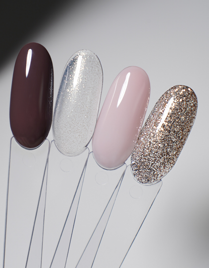 Nail polish swatch set with four glossy tips in dark burgundy, silver glitter, blush pink, and gold glitter.