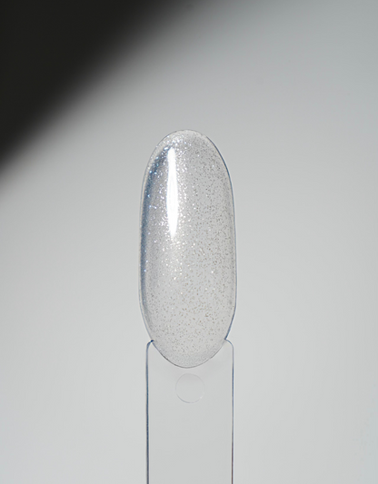 Glossy nail polish swatch tip in silver glitter on a clear display holder.