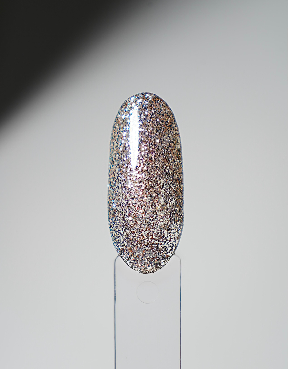 Glossy nail polish swatch tip in dense gold-and-silver glitter on a clear display holder.