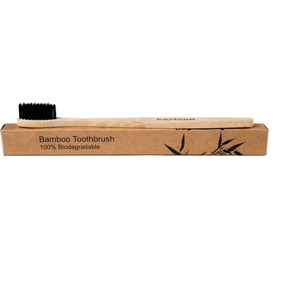 Bamboo toothbrush in cardboard tray, black bristles on top