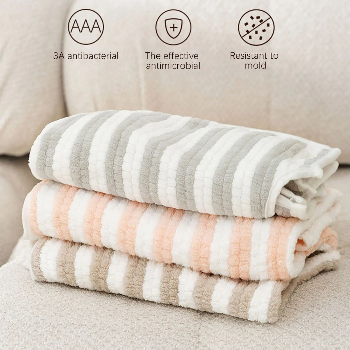Stack of dog bath towel robes in gray, white, and peach striped colors