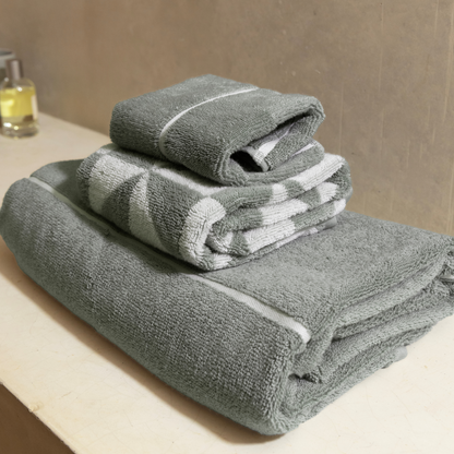 Sage green cotton bath towels, stacked with white striped bands