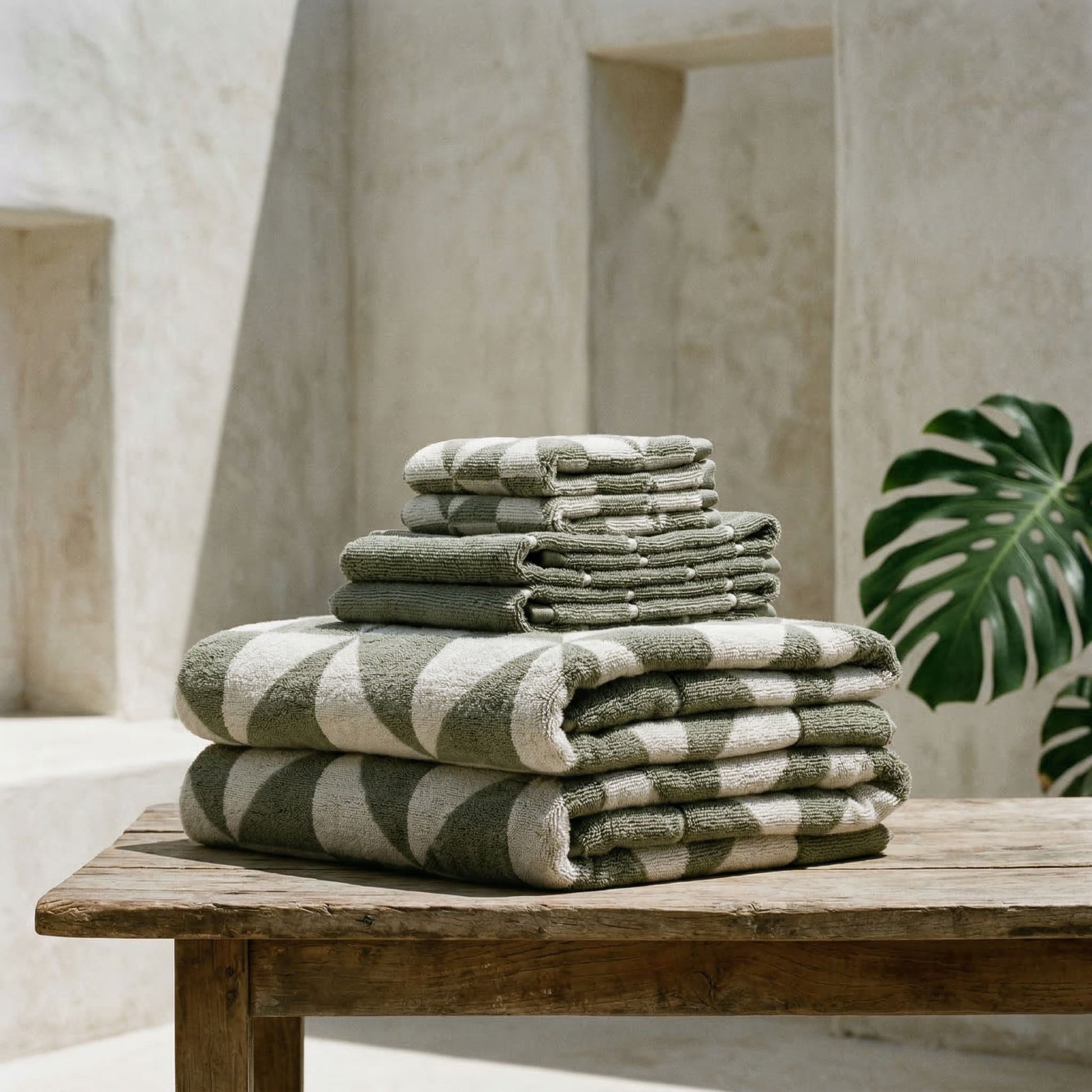 Cotton beach towel stack on a ledge, gray-green and white geometric triangle pattern